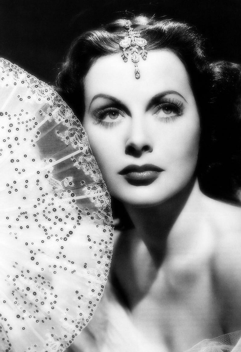 Actress Hedy Lamarr in balck-and-white hold fan, with head jewelry.