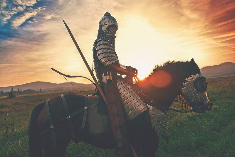 A knight on a horse in the sunrise.